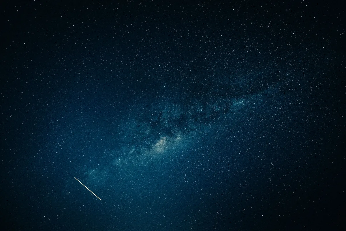 Captivating view of the Milky Way galaxy and a shooting star across a clear night sky.